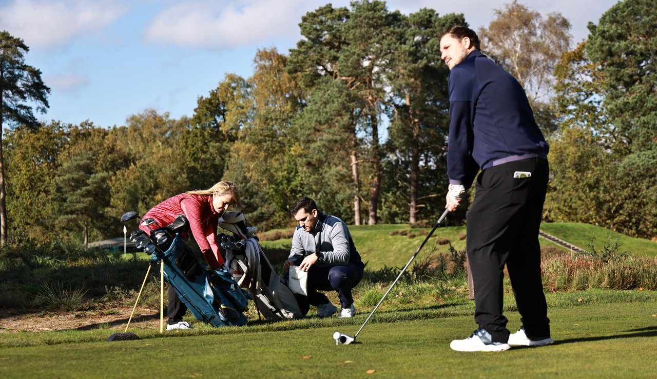 A golfer lines up a tee shot with a driver