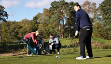 A golfer lines up a tee shot with a driver