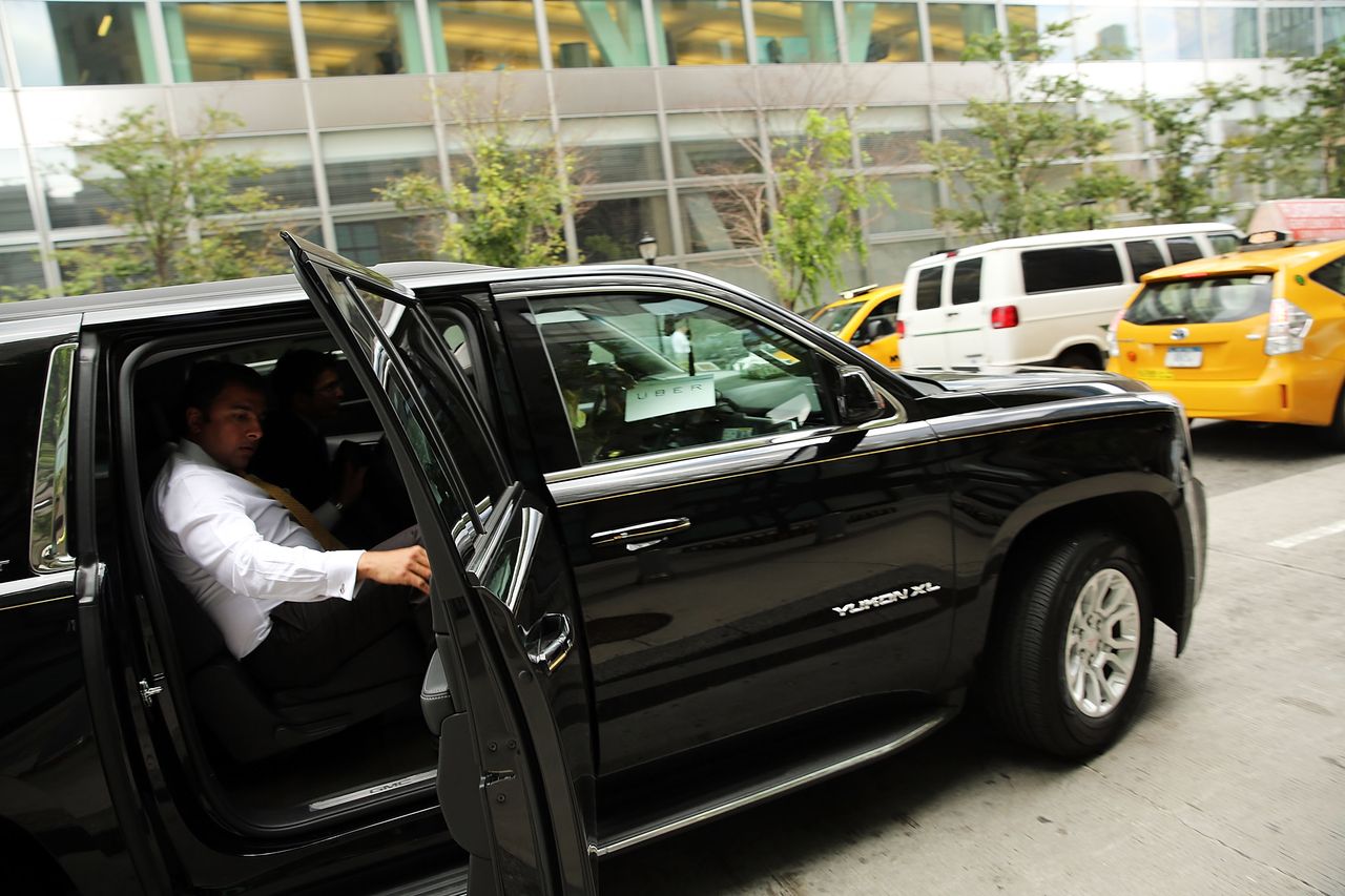 A passenger exits an Uber in New York City.