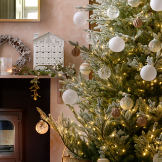 Detail of traditional Christmas tree with white frosted baubles.