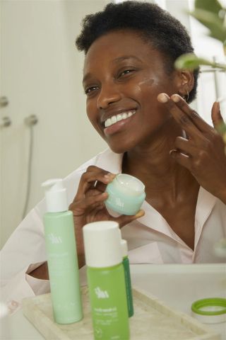 ule skincare woman applying cream to her face
