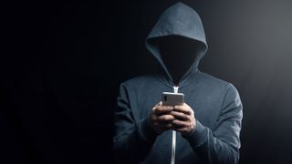 A dark figure in a hoodie representing a hacker.