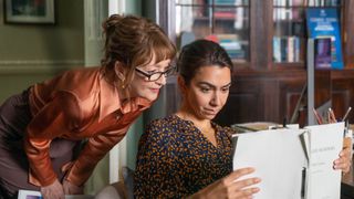 Susan (Lesley Manville) looks over Alice's (Danielle Ryan) shoulder at a manuscript in Magpie Murders