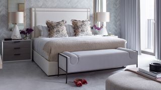 Image shows the Four Seasons mattress in an opulent hotel room furnished with a chaise lounge, large bedside table lamps and thick light grey carpeting
