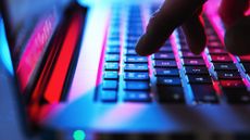 A close up of a finger hovering over the 2 key on a laptop keyboard