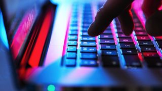 A close up of a finger hovering over the 2 key on a laptop keyboard