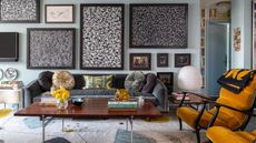 Living room with vintage sofa, yellow vintage chairs, retro rug, coffee table and monchrome wall art