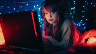 The best laptops for gaming: a photo of a woman playing on a laptop in the dark