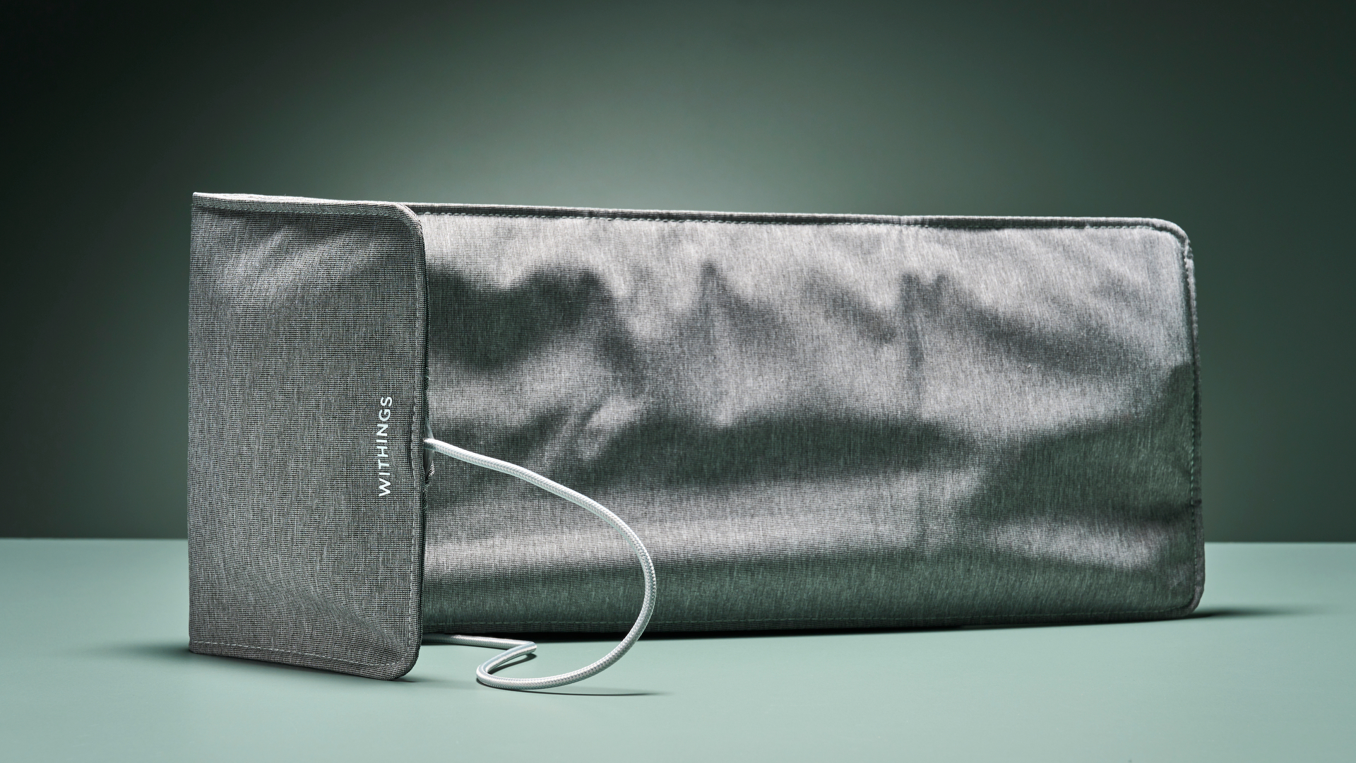 The grey Withings sleep tracking mat against turquoise background