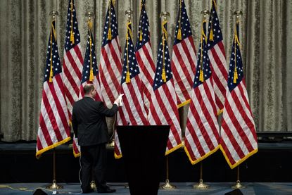 A campaign staffer steams the American flags before Republican presidential candidate Donald Trump and vice presidential running mate Mike Pence appeared together at the Hilton Midtown Hotel 