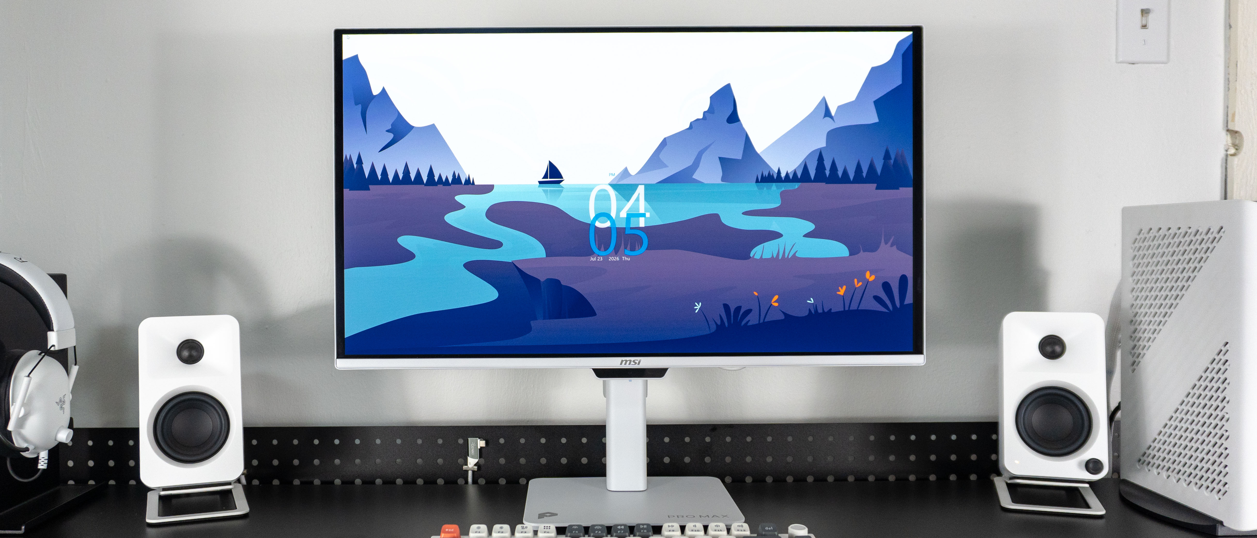 The MSI Pro Max 271UPXW12G monitor surrounded by white peripherals on a desk