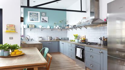 grey galley kitchen with a pink floral blind, skylight and wooden flooring