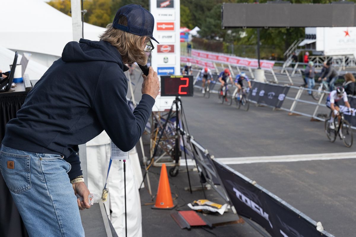 Bill Elliston, stage announcer for Friday's C1 event, tries to get a good look at the chase group coming through with 2 laps to go.