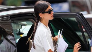 Kaia Gerber wears a library science t-shirt with sweatpants and a classic bag and sneakers