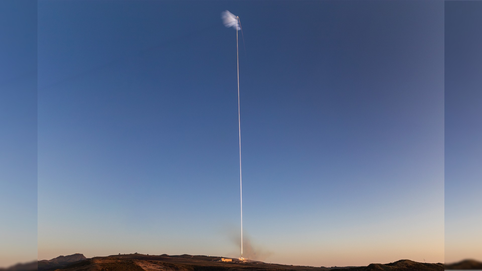 a long exposure photograph capturing a streak of fire heading into the sky