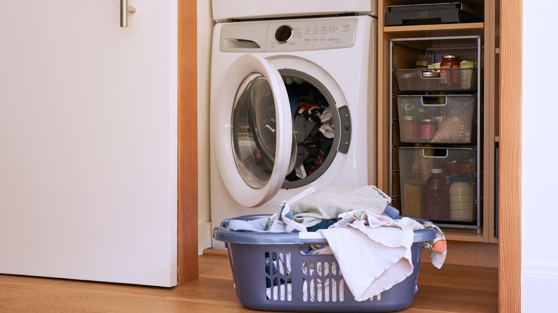 picture of basket of clothes next to open tumble dryer
