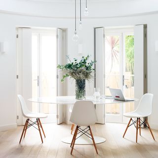 white dining room with wooden flooring and table