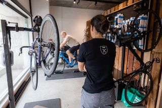 A bike fitter checking a customer's position