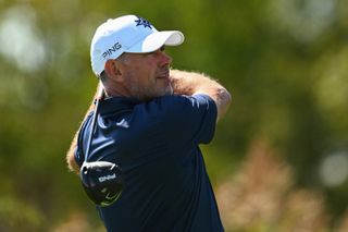 Lee Westwood strikes a tee shot and watches its flight