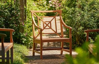 Wooden garden armchair, surrounded by greenery