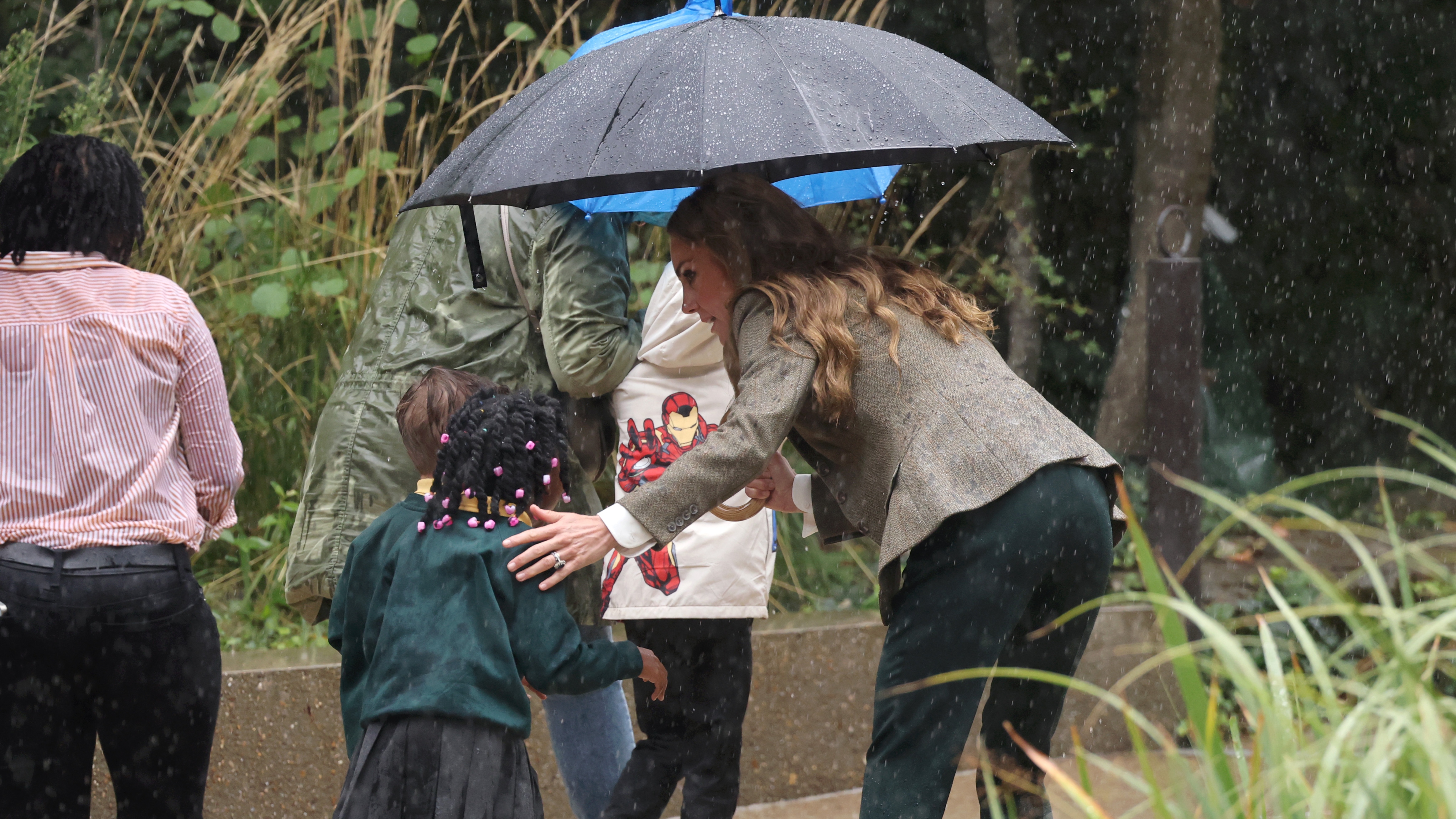 Catherine, Princess of Wales helps a child to get under her umbrella during her visit to the Natural History Museum&#039;s newly renovated gardens on September 04, 2025