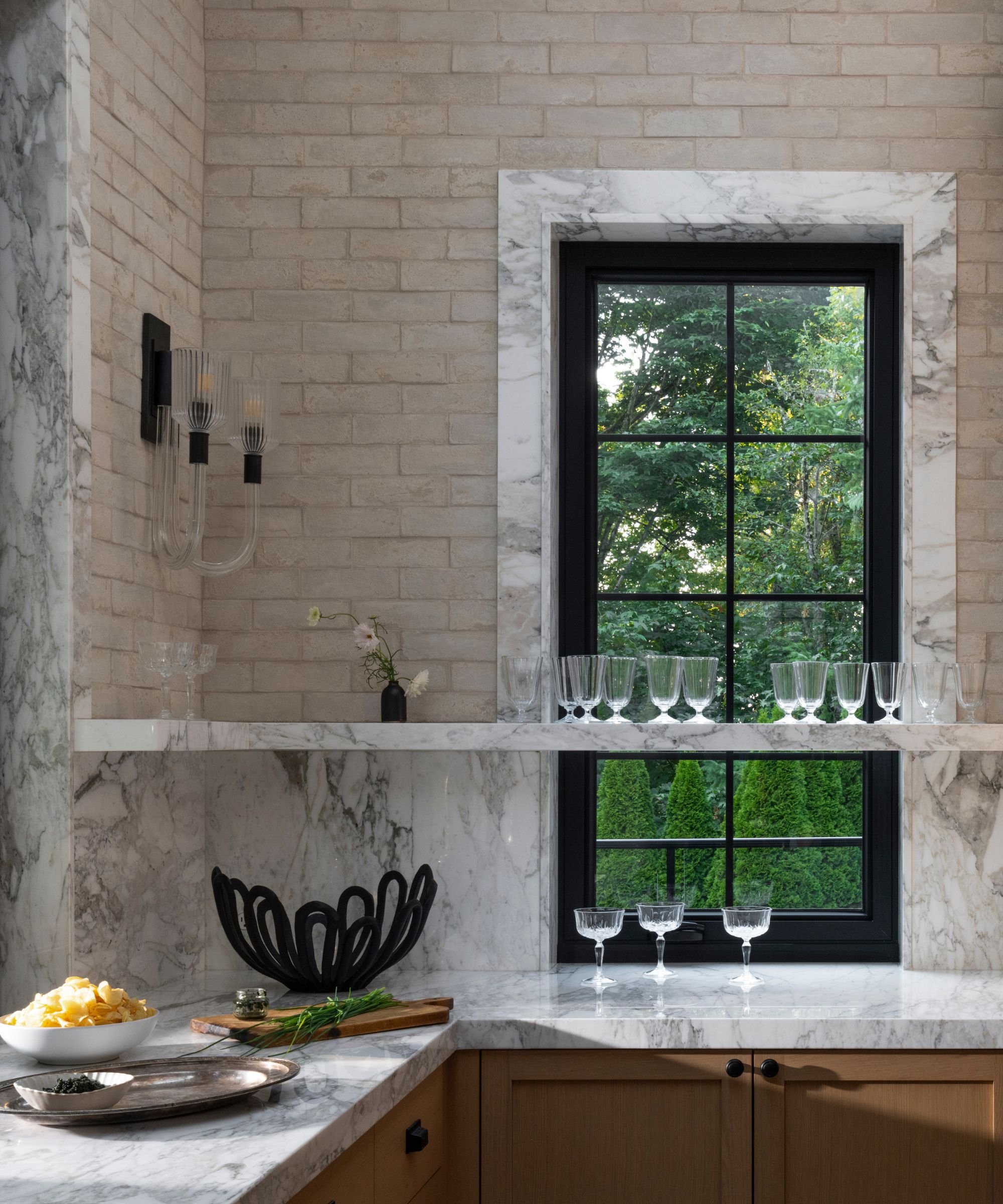 The corner of a kitchen with shelving over the windows