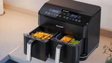 Lifestyle image of the Sharp Dual Drawer Air Fryer AF-GD82AE open with food in the two compartments