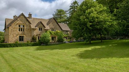 Cotswold stone cottage photographed from the lawn.