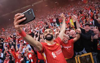 LIVERPOOL, ENGLAND - APRIL 27: Mohamed Salah of Liverpool takes a selfie with the fans, as they celebrate the teams victory and confirmation of winning the Premier League title after the Premier League match between Liverpool FC and Tottenham Hotspur FC at Anfield on April 27, 2025 in Liverpool, England. (Photo by Carl Recine/Getty Images)