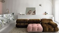 a white modern living rom wth a green and pink camaleonda sofa