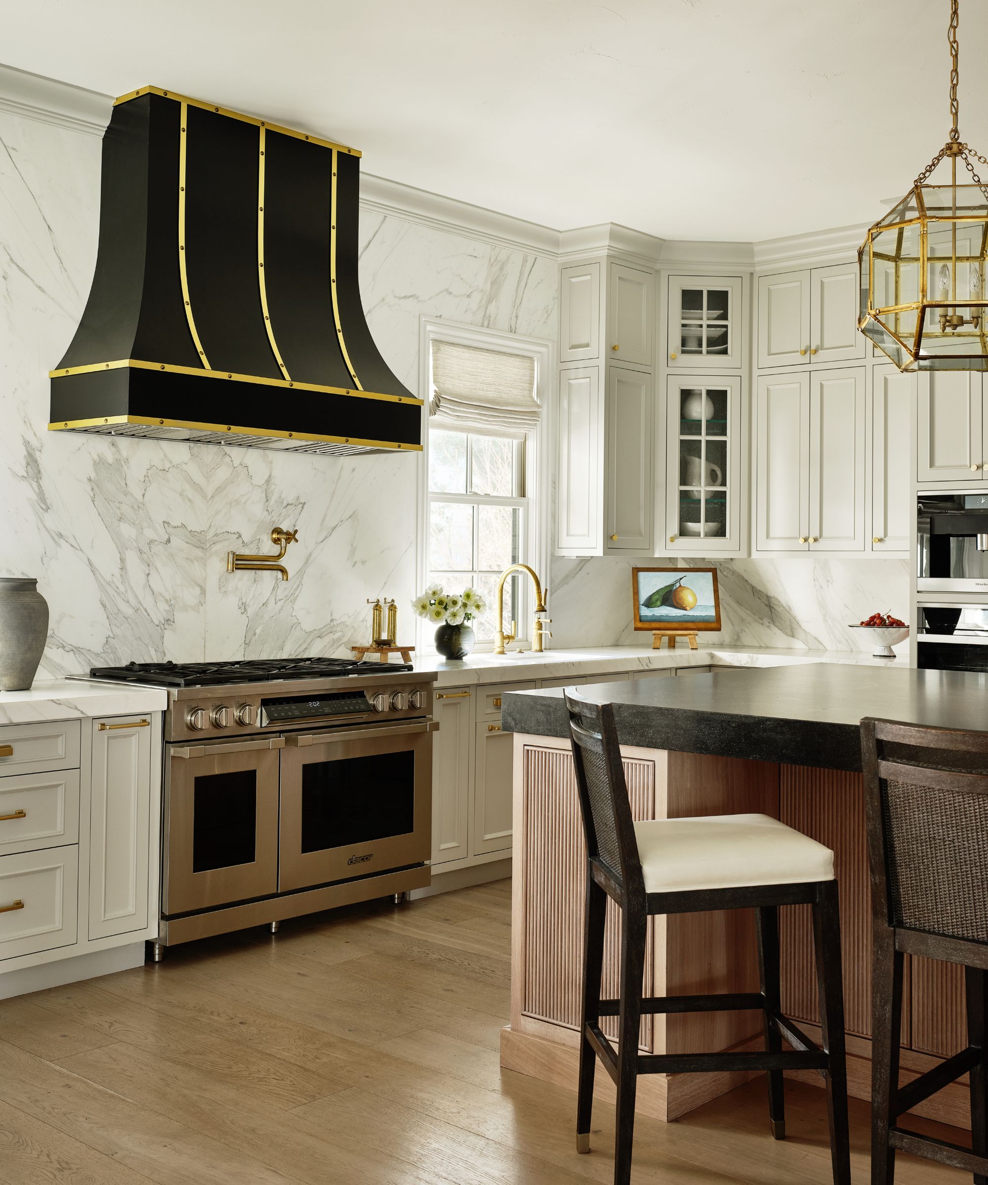 kitchen with cream units white walls black cooker hood and wood island detail