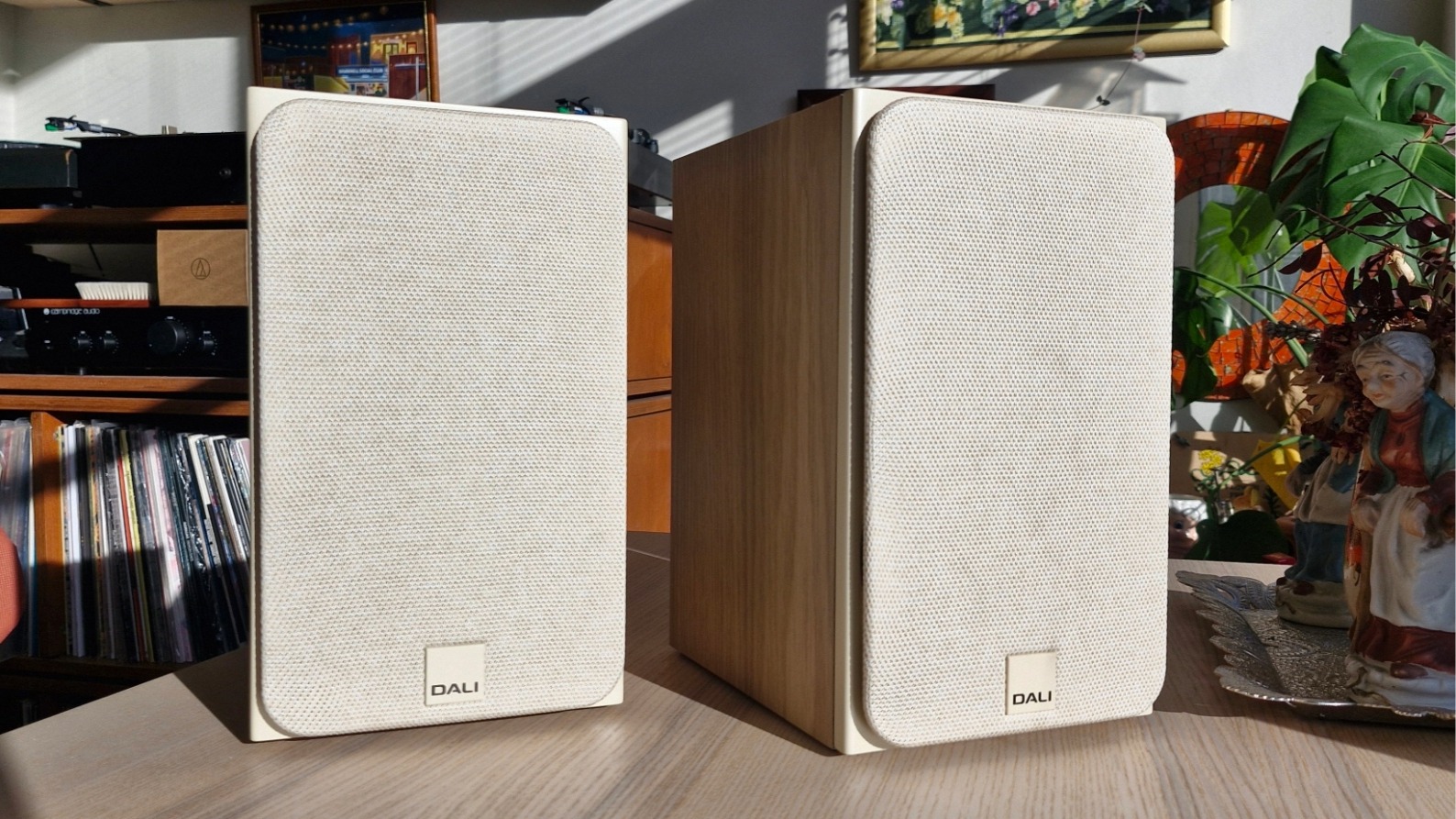 Dali Sonik 1 passive bookshelf speakers on a wooden surface.
