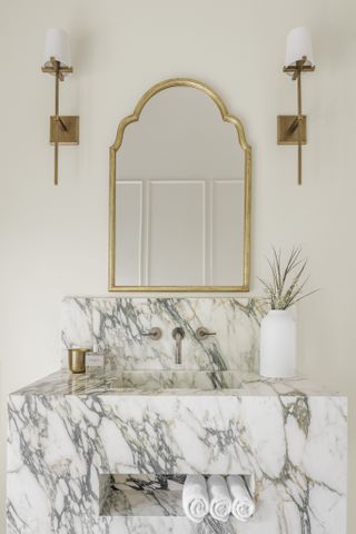 A white toned bathroom with brass details