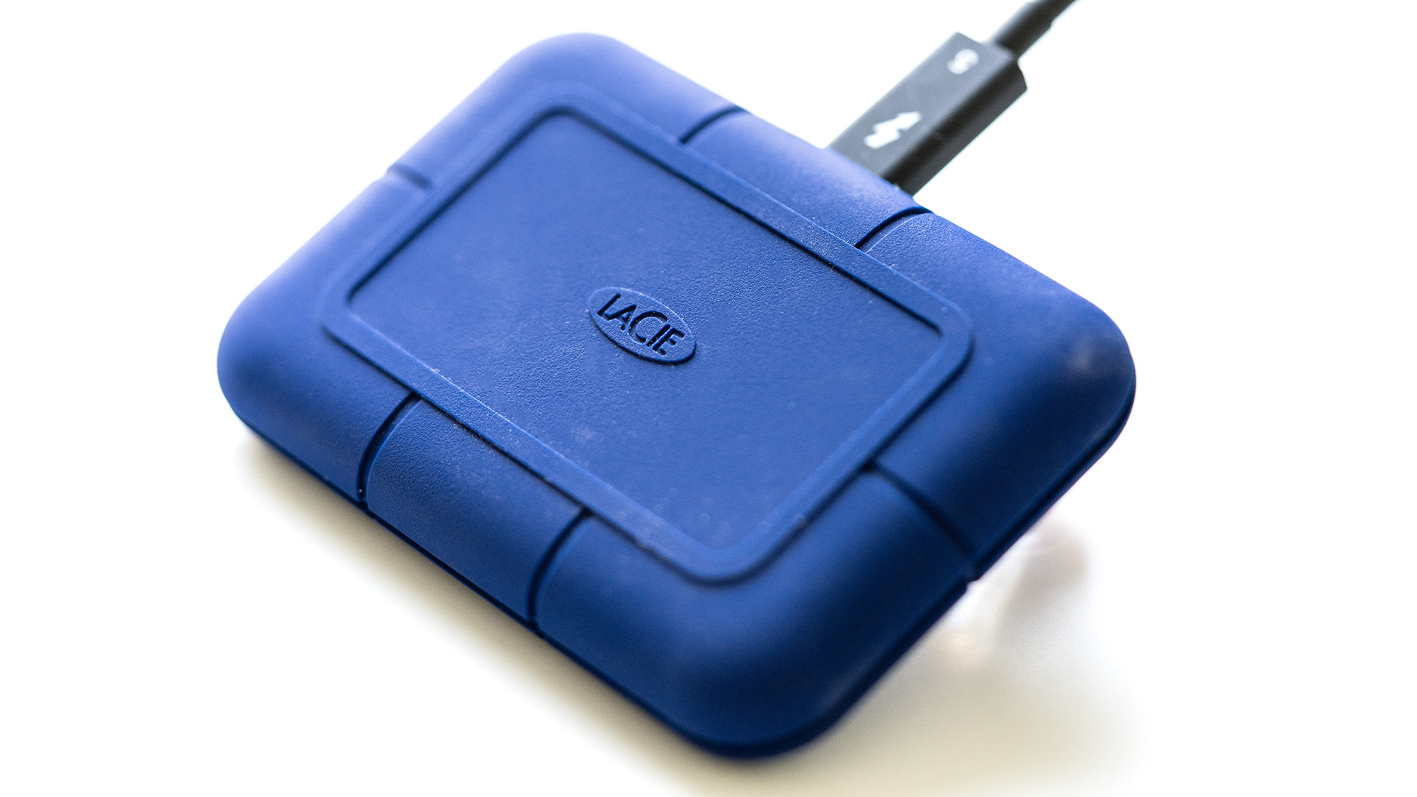 The LaCie Rugged Pro 5 in blue on a laptop and on a white background.