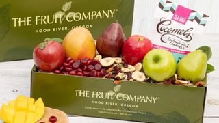 A basket of fruit inside a box with branding for The Fruit Company.