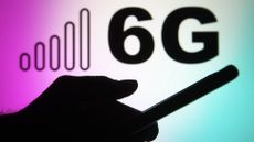 Silhouette of somebody holding a smartphone against a background with 6G written onto it