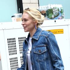Lindsay Lohan wearing a denim jacket, denim jeans, black uggs, and brown Hermes bag