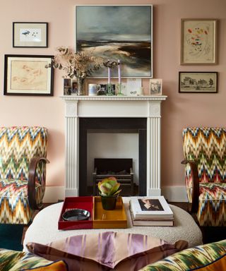 living room with white fireplace and pink walls with bentwood chairs with zig zag pattern and shaped ottoman