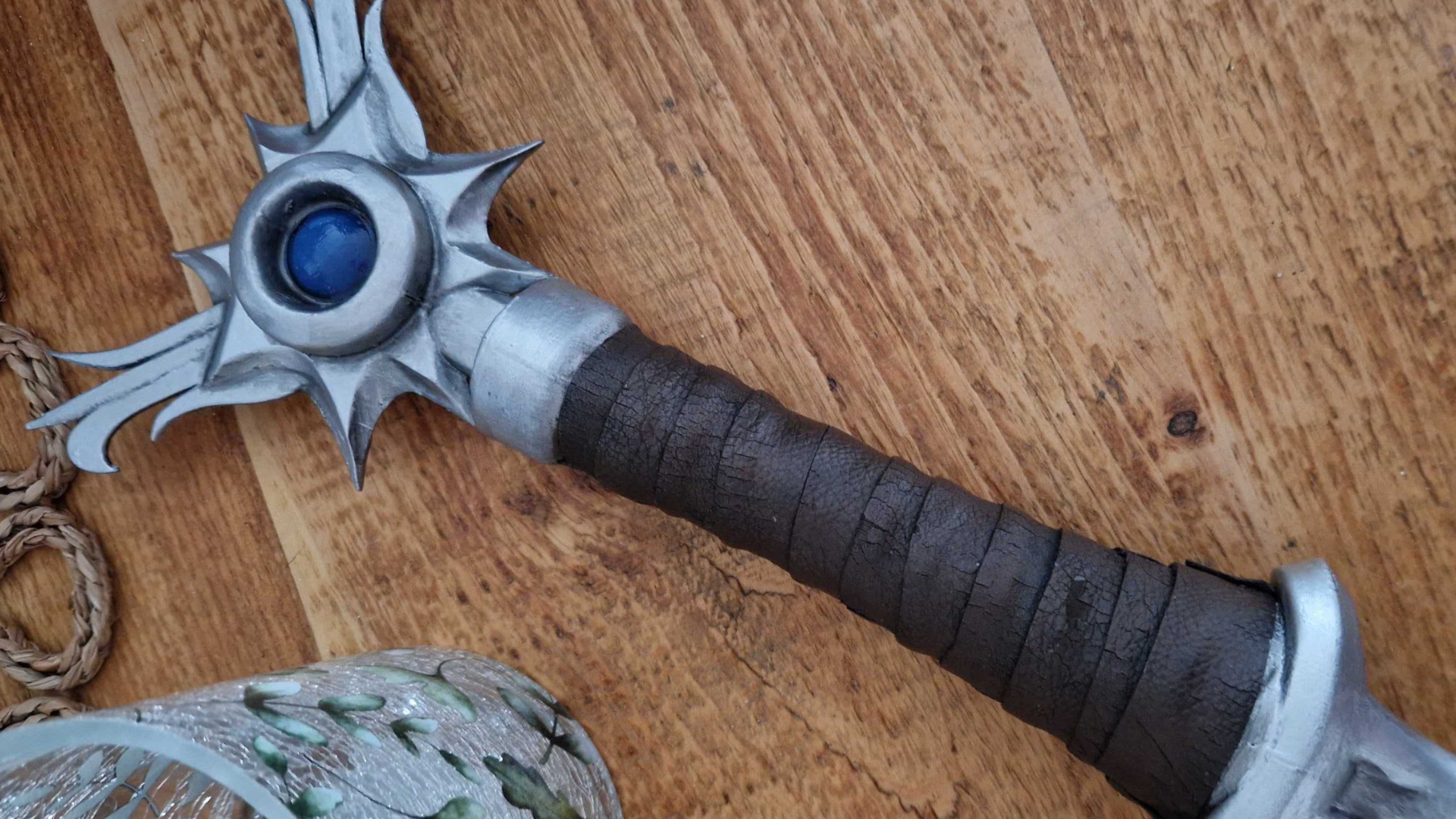 A physical Sunsword prop lying on a wooden table