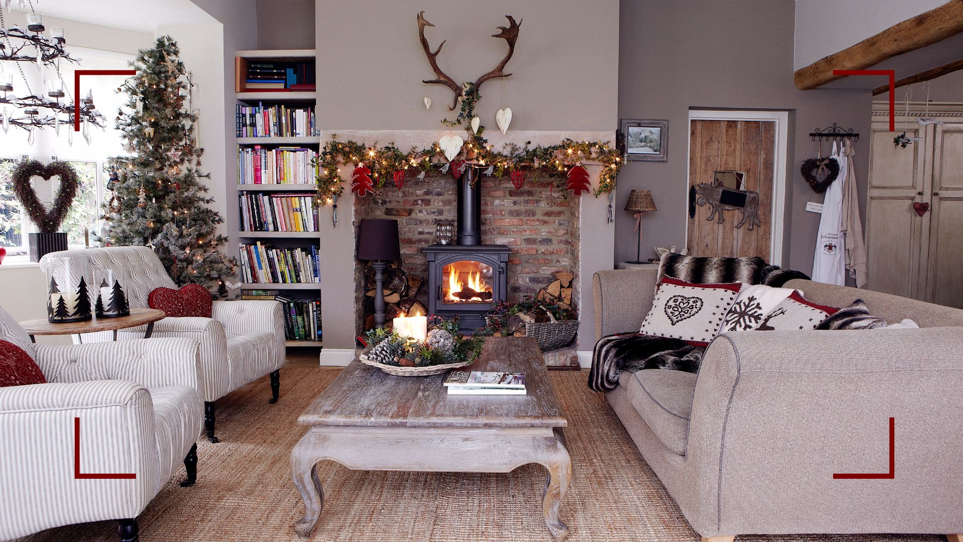 Neutral country living room with log burner in an open brick fireplace and two armchairs facing a beige linen sofa