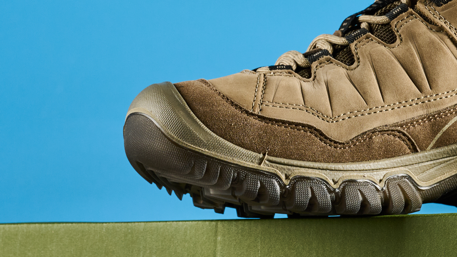 Keen Targhee IV hiking boots photographed in front of a blue background.