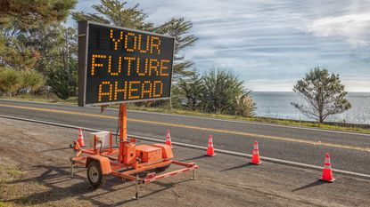 A lighted road construction sign says Your Future Ahead.