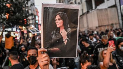 A protester holds a portrait of Mahsa Amini during a demonstration in Turkey against the Iranian regime 