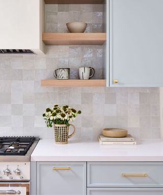 Pale sky blue kitchen cabinets with marble tiles backsplash