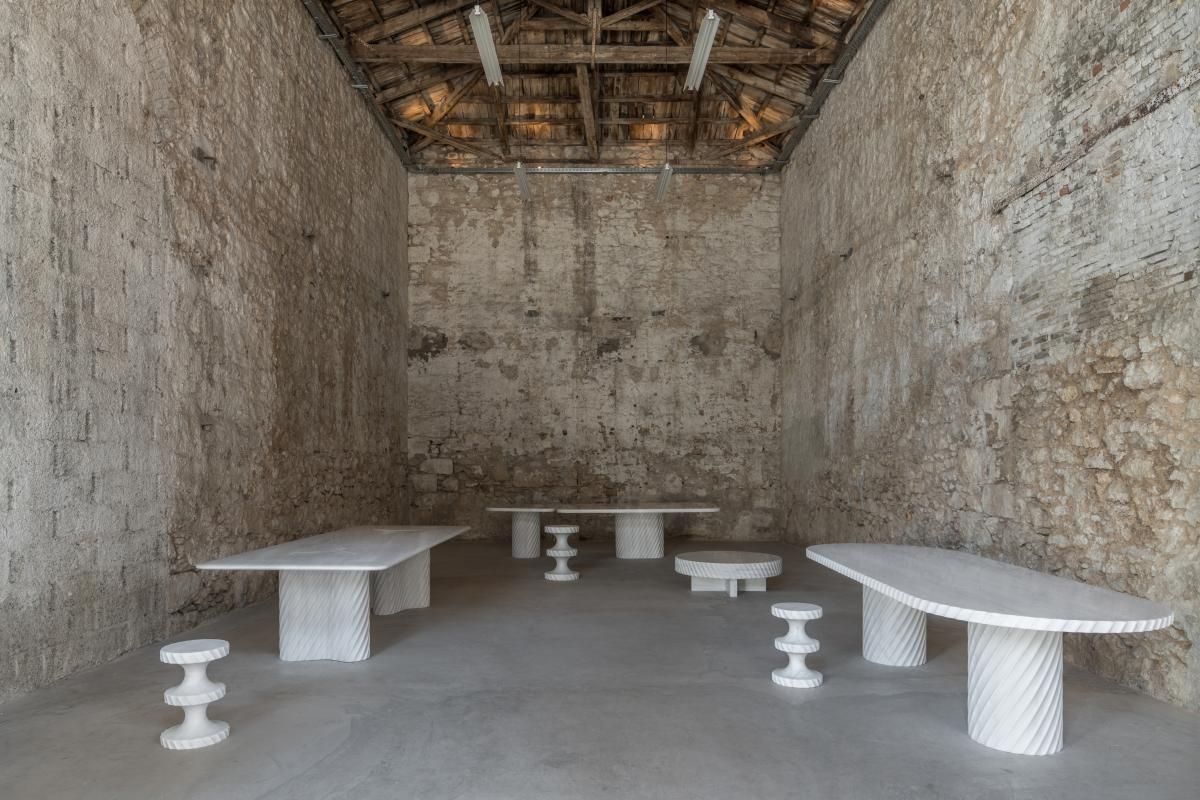 White marble tables and stools by India Mahdavi at Carwan gallery