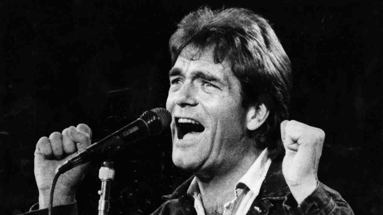 Huey Lewis performing onstage in 1985