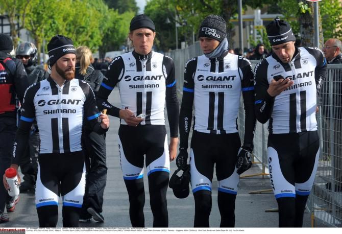 Giant-Shimano checking their phones before the start of the race