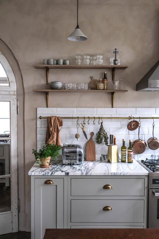 grey kitchen with marble countertop and open shelving by deVOL