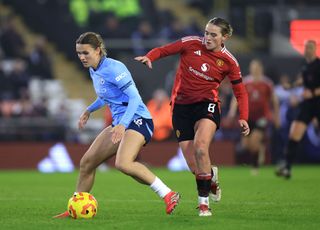 Kerstin Casparij of Manchester City is put under pressure by Grace Clinton of Manchester United during the Subway Women's League Cup match between Manchester United and Manchester City at Leigh Sports Village on January 22, 2025 in Leigh, England.