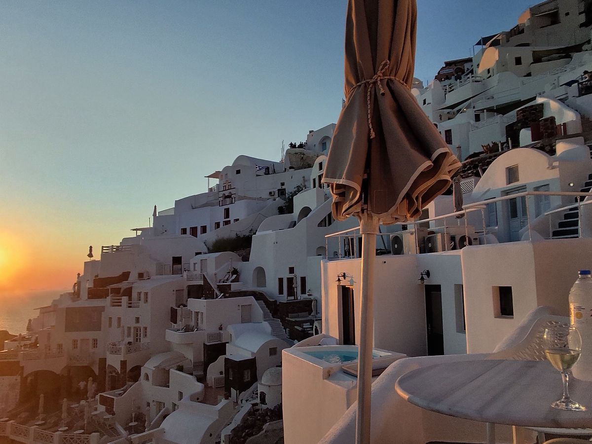 Test shots taken on the L'Atitude 52 smart glasses showing the white buildings of Oia as the sun sets